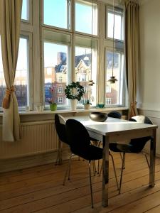 Una mesa y sillas en una habitación con ventanas. en Aaboulevard Apartment, en Copenhague