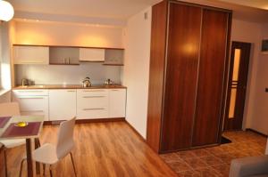 a kitchen with white cabinets and a table and chairs at Apartament Bajkowy samodzielne mieszkanie in Busko-Zdrój