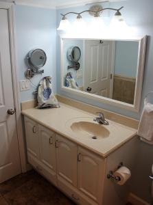 a bathroom with a sink and a large mirror at Jupiter Reef Club Resort in Jupiter