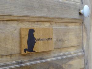 a sign with a black bear on a wooden door at Le Grand Chalet in Aspet