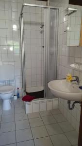 a bathroom with a shower and a sink and a toilet at Wohnung 3 mit Terrasse Haus Annegrete in Bensersiel