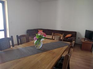 una mesa de comedor con un jarrón de flores. en Apartments Kuzman, en Dubrovnik