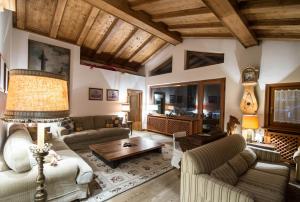 a living room with two couches and a table at CanguroProperties - Ca' Mora in Cortina dʼAmpezzo