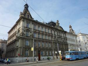 a bus is parked in front of a large building at Apartment Al Centro in Olomouc