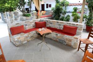a stone bench with red chairs and a table at Maria Studios in Neo Klima