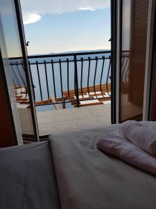 a balcony with a bed and a view of the ocean at Grandpa's dream in Lokva Rogoznica