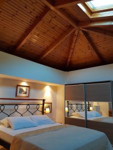 a bedroom with two beds and a wooden ceiling at Villa Avra in Poros