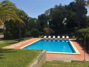 einen Pool mit zwei Gartenstühlen in der Unterkunft Soltroia Housefeelings in Troia