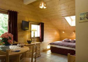 ル・グラン・ボルナンにあるStudio Bel'Alpのログキャビン内のベッドルーム(テーブル、ベッド付)