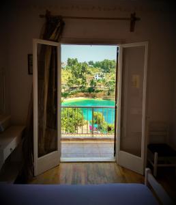 an open door to a balcony with a view of a pool at Magdalini in Votsi