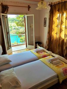 two beds in a room with a large window at Magdalini in Votsi