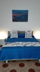 een blauw bed met een blauw en wit dekbed bij Il Ponte in Napels