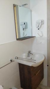een badkamer met een wastafel en een spiegel bij Aria di Casa in Porto Cesareo