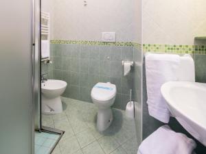 a bathroom with a toilet and a sink at Appartamenti Lira in Cattolica +4 photos