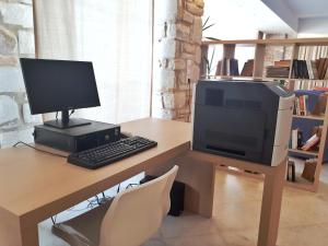 a desk with a computer and a monitor and keyboard at Saint George Hotel in Chrissi Akti