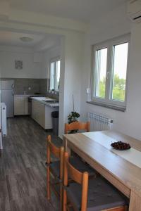 a kitchen with a large wooden table and chairs at Apartment Piranesi with a parking space in Pula