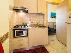 a kitchen with a stove and a microwave at Appartamenti Lira in Cattolica
