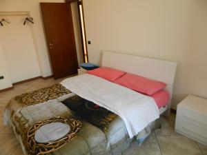 a bedroom with a bed with white and red pillows at Appartamento Mira in Cislago