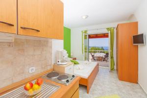 a kitchen with a counter with a bowl of fruit at Sunny House Free Parking in Trsteno
