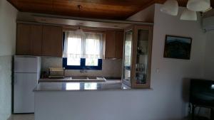 a kitchen with a white refrigerator and a window at Vlachogiannis EL Estate in Skala Rachoniou