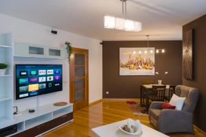 a living room with a television and a dining room at Alojamiento Santa Maria in Milladoiro