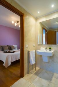 baño con lavabo y cama en Alojamiento Santa Maria en Milladoiro