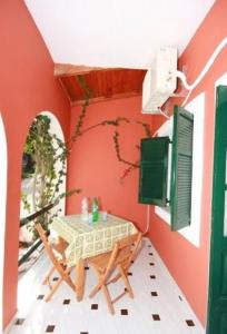 a table and chairs in a room with red walls at Paleopalace in Paleokastritsa
