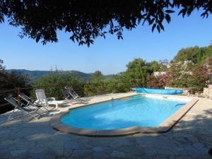 a swimming pool with two chairs and a table at Mas des Citronniers in Le Tignet