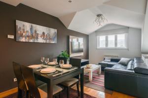 a living room with a table and a couch at Alojamiento Santa Maria by GaliciAway in Milladoiro