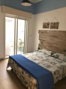 トッレ・ラピッロにあるAppartamento Chiaraのベッドルーム1室(大型ベッド1台、木製ヘッドボード付)