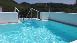 Ein Swimmingpool mit blauem Wasser und Bergen im Hintergrund in der Unterkunft Su Pasciale in Nulvi