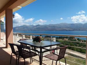 a table on a balcony with a view of the water at Loggos view apartments in Lixouri