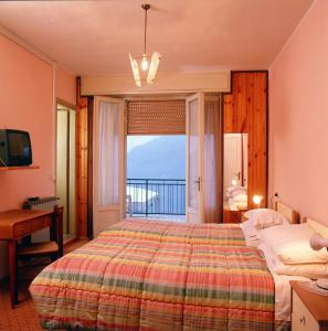 una camera con letto e vista sull'oceano di Hotel Poggio d'Oro a Riva di Solto