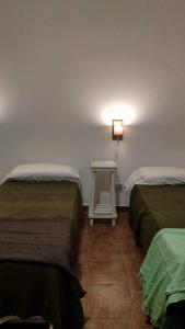 a room with two beds and a small table at Santo Domingo in Esquina +4 photos