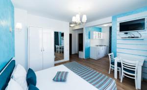 a bedroom with a white bed and a dining room at Stela Apartments in Obzor