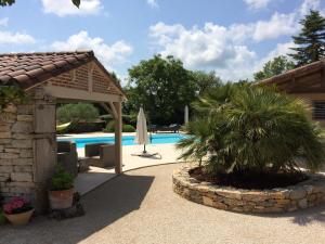 uma piscina com um pavilhão ao lado de uma casa em Le Couvent em Saint-Jean-de Laurs