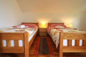 two twin beds in a bedroom with two lamps at Apartment Medeni in Rakovica
