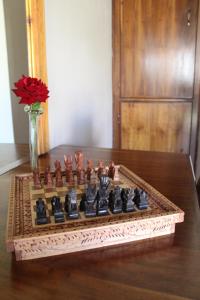 un tablero de ajedrez sobre una mesa con un jarrón de rosas en Jarina Guesthouse, en Wolmaranstad