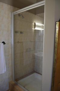 una ducha con puerta de cristal en un baño en Jarina Guesthouse, en Wolmaranstad 13 fotos más