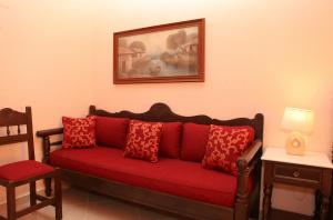 a red couch with red pillows in a room at Maria Studios in Neo Klima