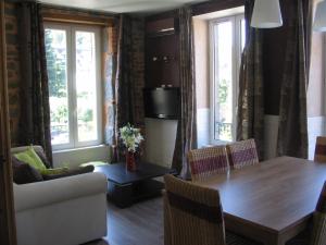 a living room with a wooden table and a couch at La Vallée in Le Mont-Dore