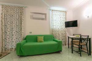 a green couch in a living room with a table at Casa Pamela in Capri