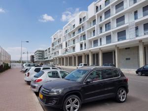 une rangée de voitures garées devant un grand bâtiment dans l'établissement residence agadir bay founty, à Agadir