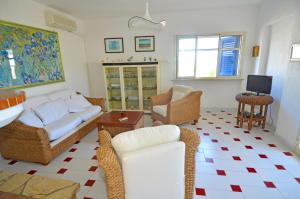 a living room with a couch and chairs and a tv at Casa Tramonto - RosariaVacanze in Leuca