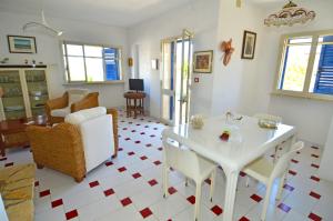a living room with a white table and chairs at Casa Tramonto - RosariaVacanze in Leuca