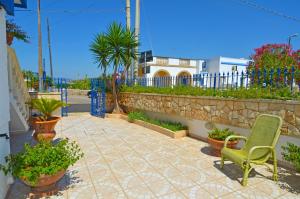 a patio with a green chair and some plants at Casa Tramonto - RosariaVacanze in Leuca