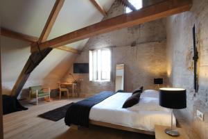 a bedroom with a large bed in a brick wall at 'S Hertogenmolens Hotel in Aarschot