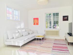 Sala de estar blanca con sofá blanco y alfombra en Family villa near sea and Stockholm city, en Estocolmo