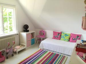 Dormitorio pequeño con cama con almohadas coloridas en Family villa near sea and Stockholm city, en Estocolmo