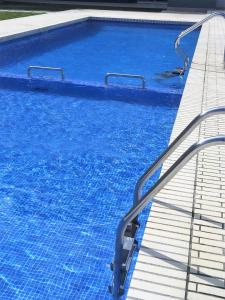 una piscina con agua azul y escaleras en ella en Apartment Ramon, en Sant Antoni de Calonge